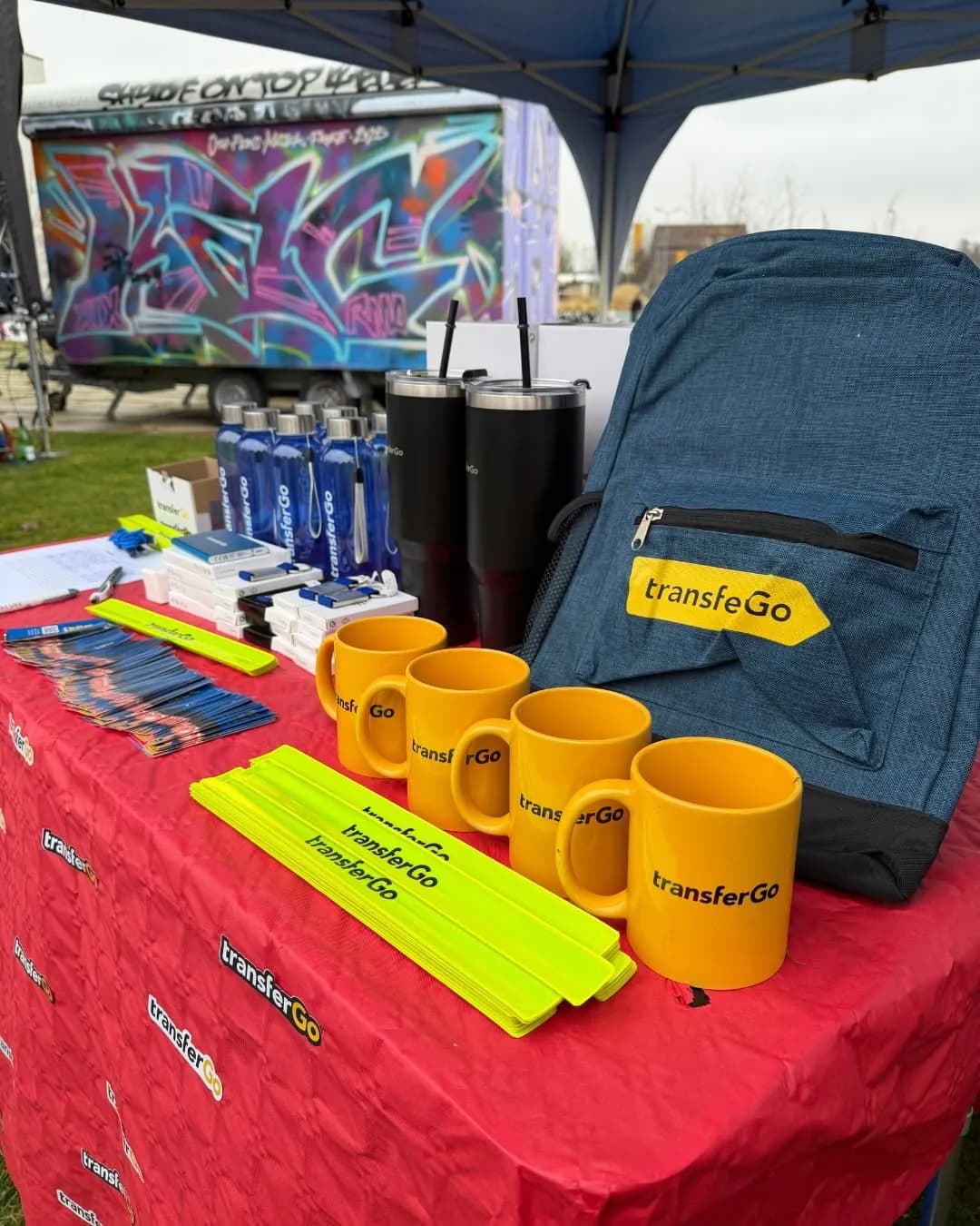 Attendees collecting TransferGo merchandise at a community market stall