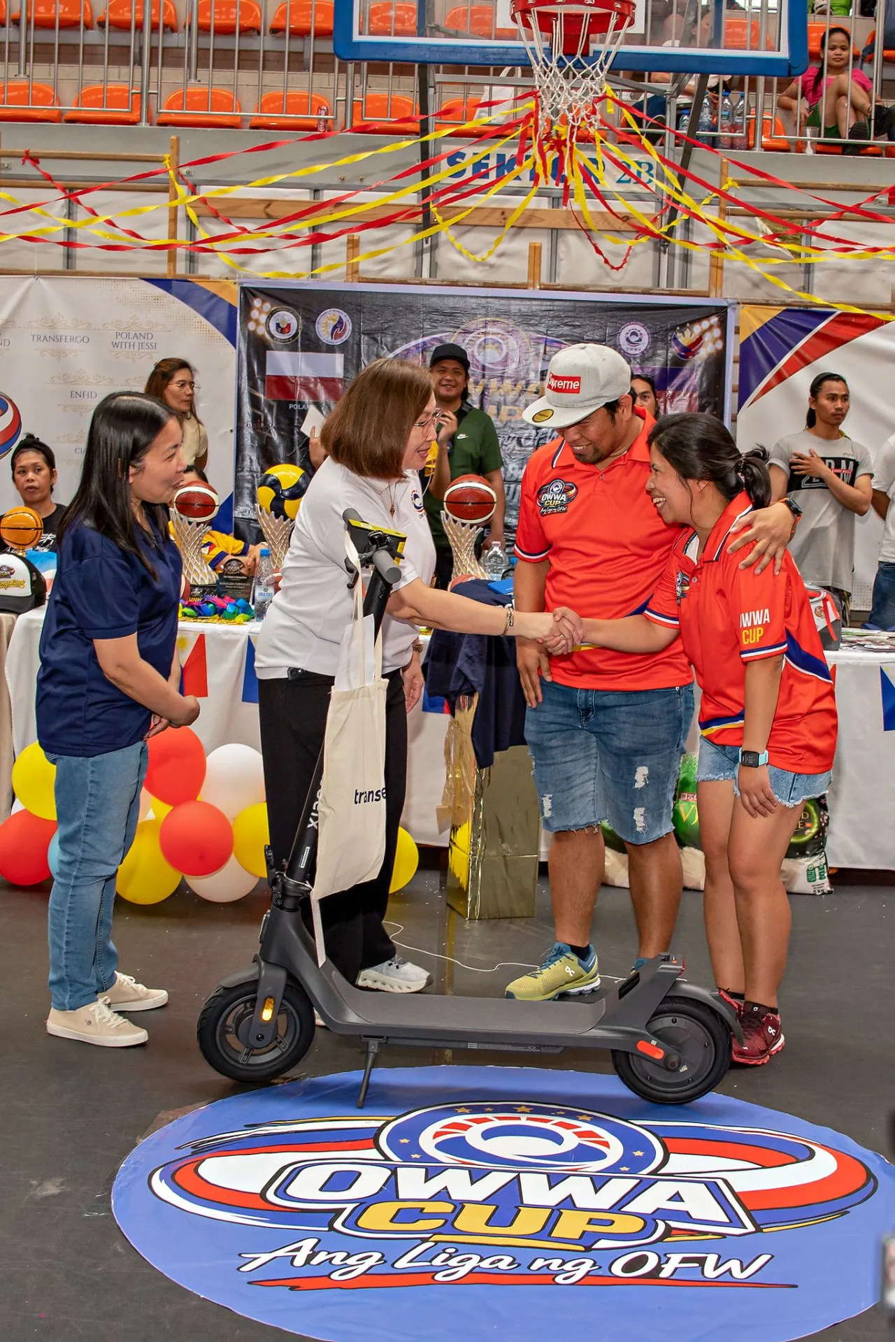 TransferGo brand ambassador handing over a prize at the OWWA Cup