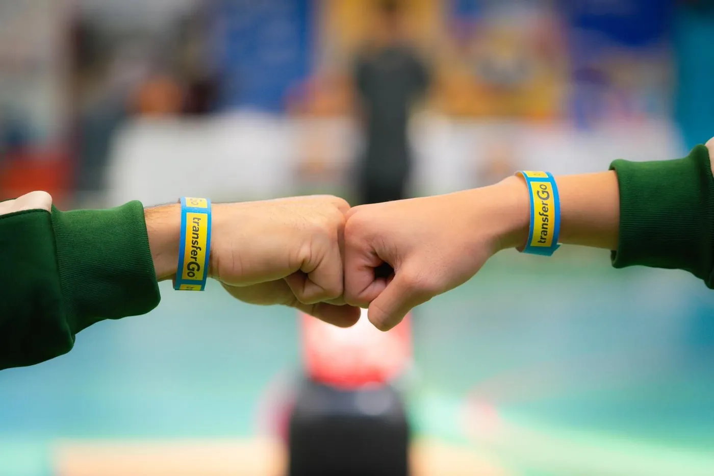 Fist bump with TransferGo branded wristbands at the community tournament